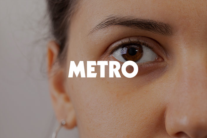 A younger woman stares into the camera with slight dark circles under the eyes with the Metro logo superimposed on top