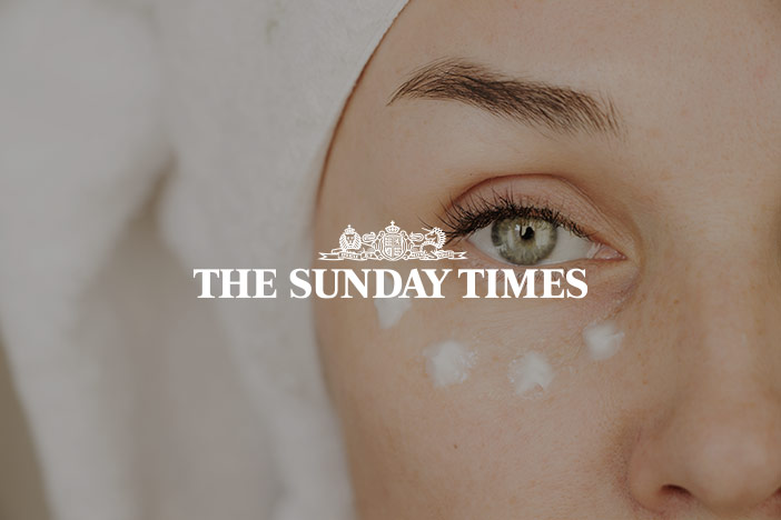Middle aged woman with eye cream under the eye and a towel turban looks towards the camera. 'The Sunday Times' logo is superimposed on top. 
