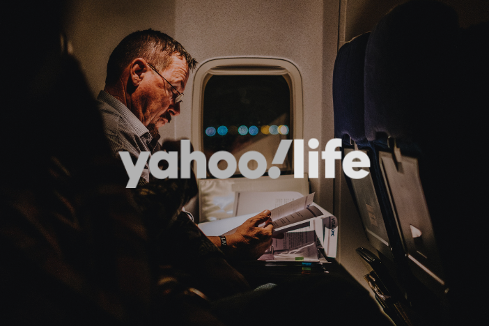 Man on a plane wearing glasses with Yahoo! Life logo imposed