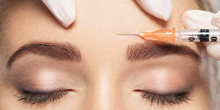Woman receiving Botox anti wrinkle injection in the forehead area with a needle