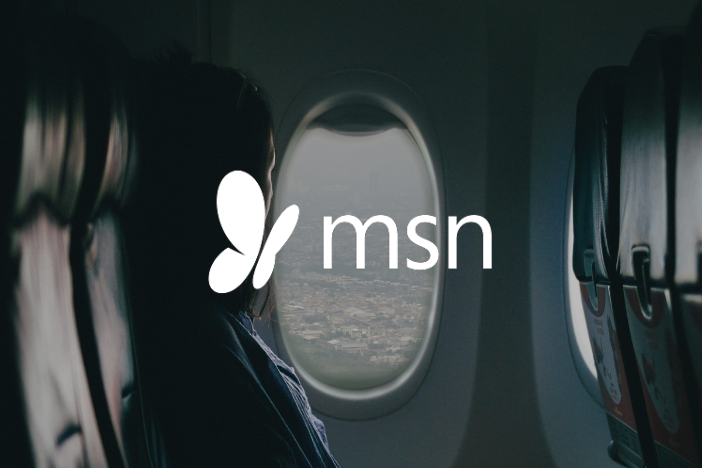 Woman on a plane wearing glasses with MSN logo imposed