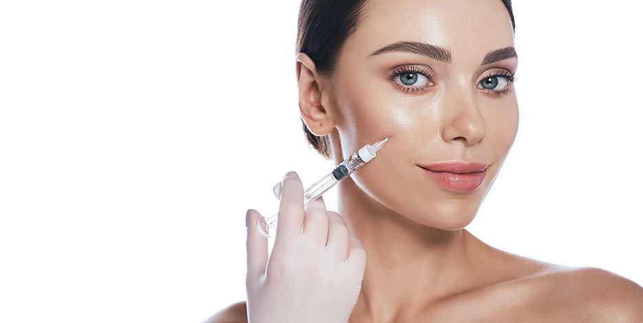 Women with glowing skin receives injection to the cheek area