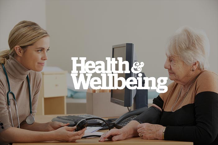UK GP consultation with Health & Wellbeing logo imposed