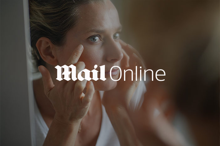 Woman inspects her eyes in the mirror. The 'Mail Online' logo is superimposed on top.