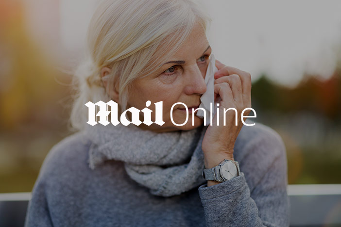 Older woman wipes a weeping eye. The 'Mail Online' logo is superimposed on top. 
