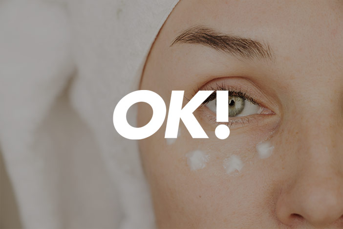 A woman stares into the camera with eye cream dotted under the eye. An 'OK!' Magazine logo is superimposed on top.