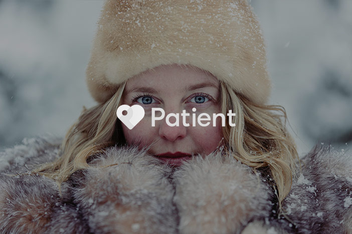 An older woman wrapped up in winter clothing looks into the camera. A 'Patient' logo is superimposed on top.