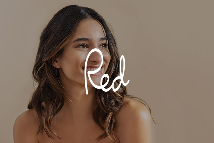 A beautiful brunette woman with good skin looks into the distance. A 'Red' Magazine logo is superimposed on top.