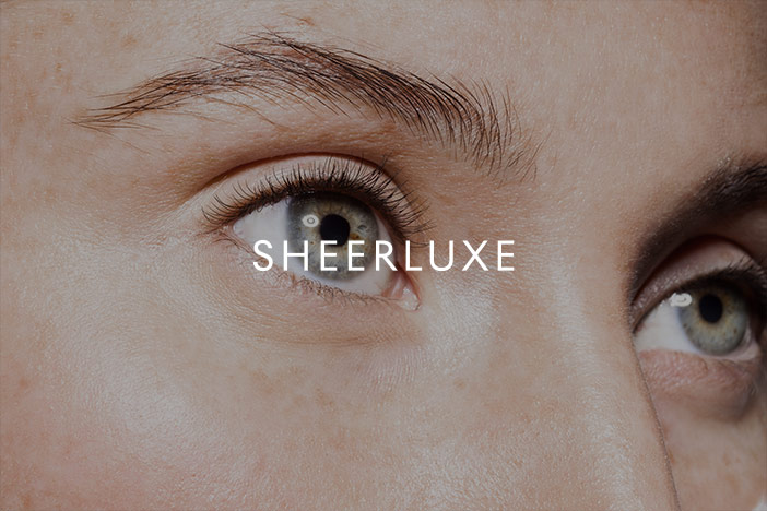 A woman with healthy looking eyes looks into the distance. A 'Sheer Luxe' logo is superimposed on top.