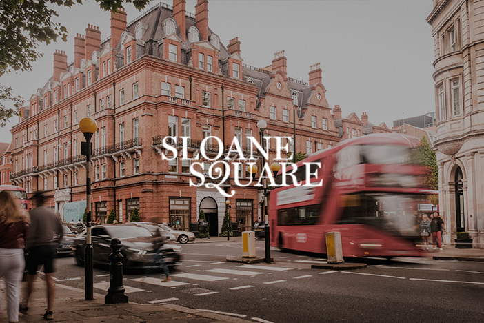 A zebra crossing and prestigious architecture of Sloane Square with bus turning round the corner. 'Sloane Square' logo is superimposed on top. 