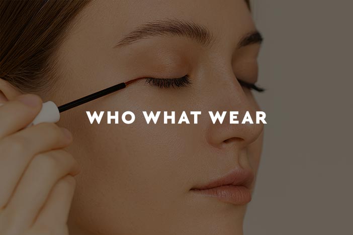 Close up of woman applying eyelash serum with applicator brush for Who What Wear UK beauty feature