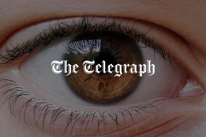 Close-up of a brown eye with The Telegraph logo overlayed