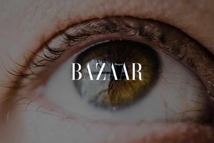 Close-up of a human eye with a green iris, with the logo "Harper's BAZAAR" superimposed at the bottom.