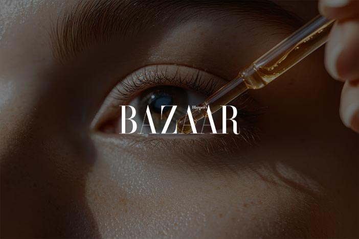 Close-up of a person's eye with a skincare dropper applying product, featuring the 'Harper's Bazaar' logo