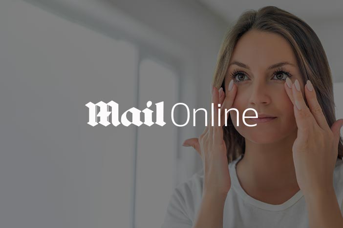 A woman placing her fingers gently under her eyes, looking at the camera, with the logo "Mail Online" in the centre.