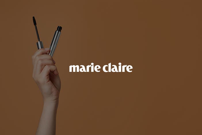 Hand holding two mascara wands with Marie Claire logo