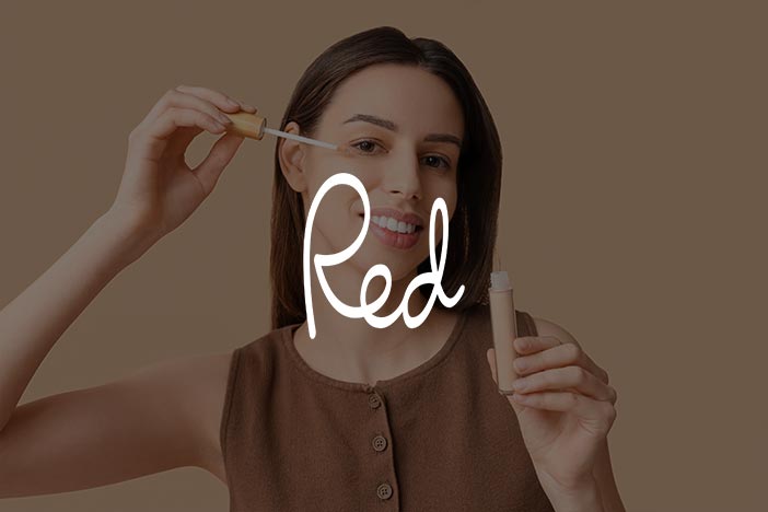 Woman applying skincare product with a dropper, featuring the 'Red' magazine logo.