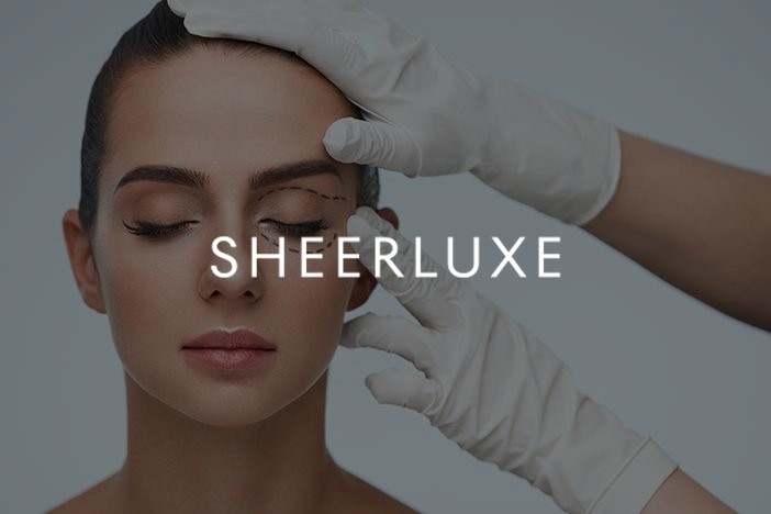 Gloved hands marking a woman's upper eyelid before surgery, SheerLuxe feature