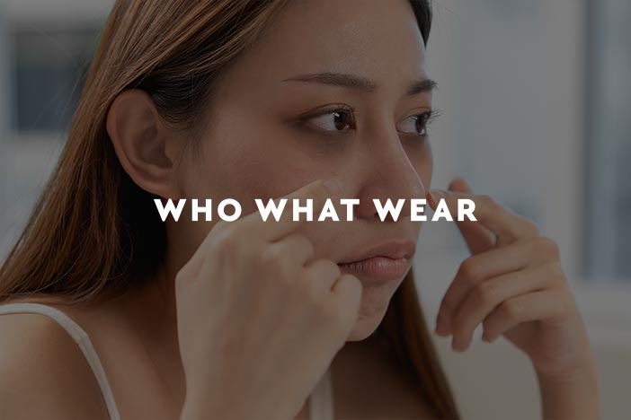 Woman applying skincare under her eyes, featured in Who What Wear article about dark circle treatments
