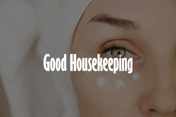 Close-up of a woman with under-eye cream dots and towel wrap, featured in Good Housekeeping article about anti-wrinkle eye creams