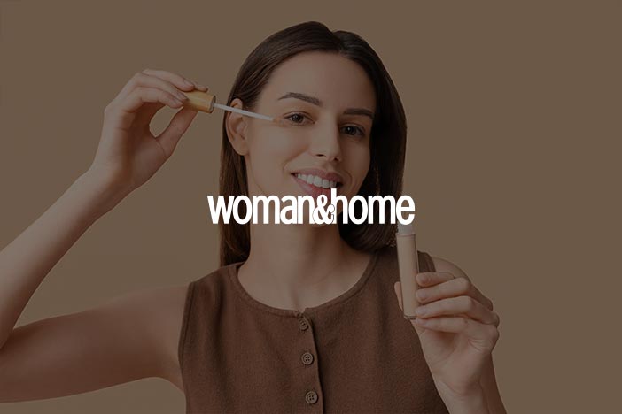 Woman holding mascara wand and tube smiling for Woman & Home beauty article on mascaras for sensitive eyes